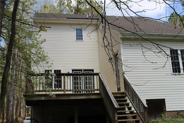 back of property featuring roof with shingles, a deck, and stairs