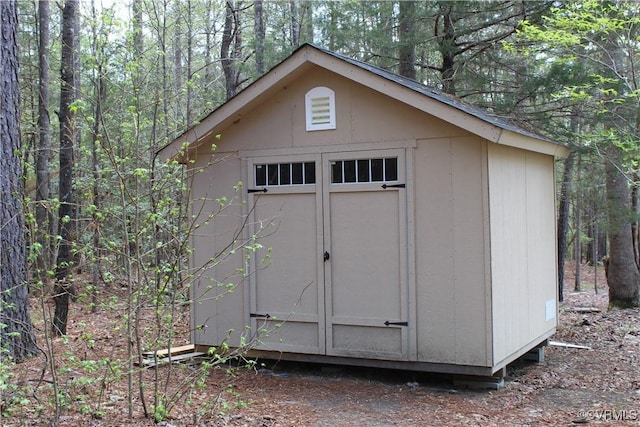 view of shed with a wooded view