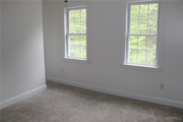 unfurnished room with baseboards and carpet flooring