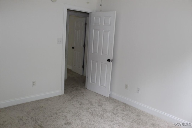 carpeted empty room with baseboards