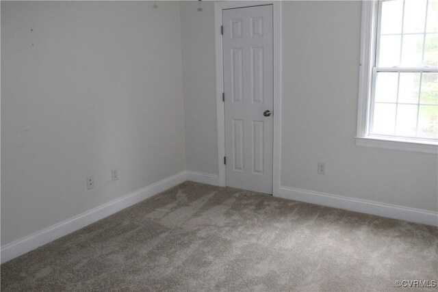 carpeted spare room with baseboards