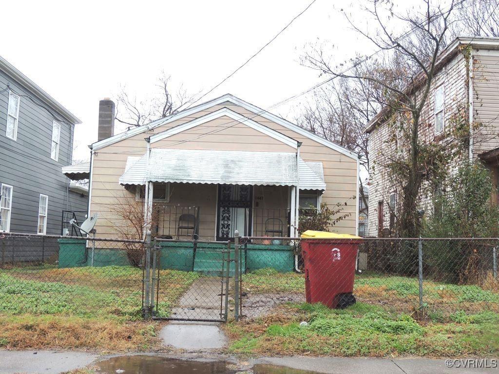 bungalow-style house featuring covered porch, a gate, and a fenced front yard