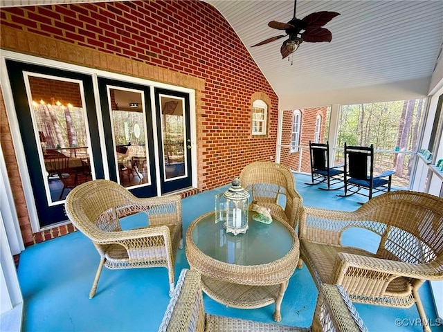 exterior space with brick wall, a ceiling fan, and lofted ceiling