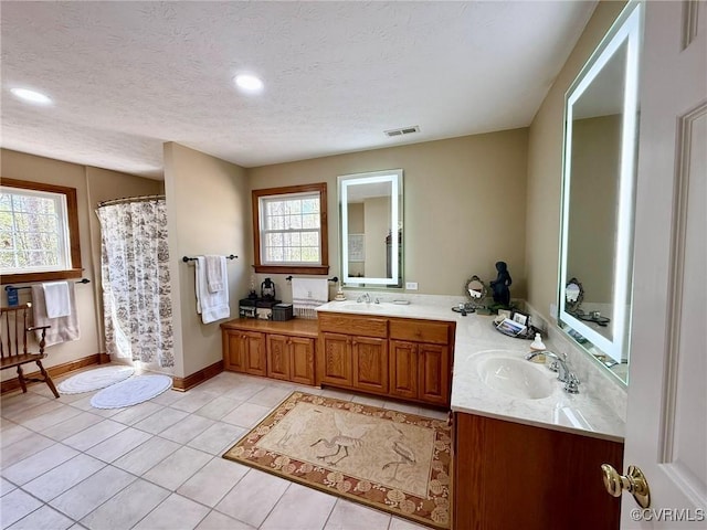 bathroom featuring a textured ceiling, vanity, visible vents, a shower with shower curtain, and tile patterned floors