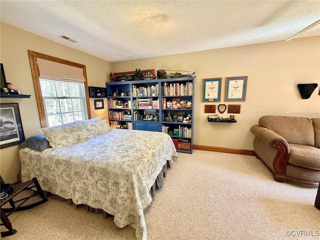 bedroom with visible vents, baseboards, light colored carpet, and a textured ceiling