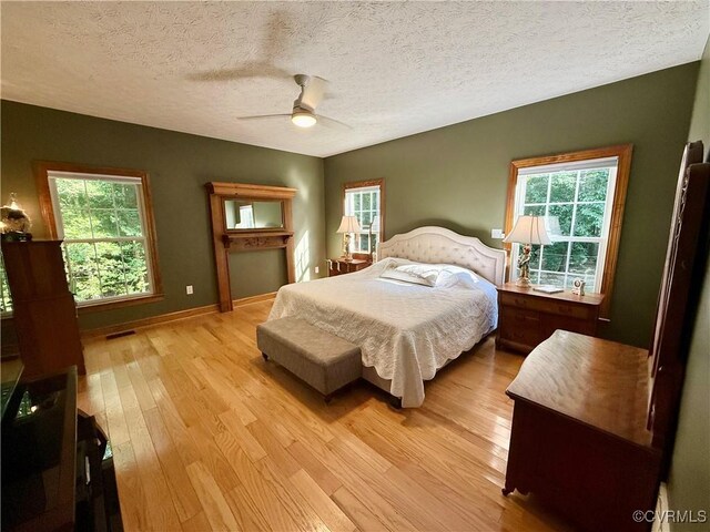 2222 Green Level Rd, King William, VA 23086 - bedroom featuring light wood-style floors, a ceiling fan, and a textured ceiling