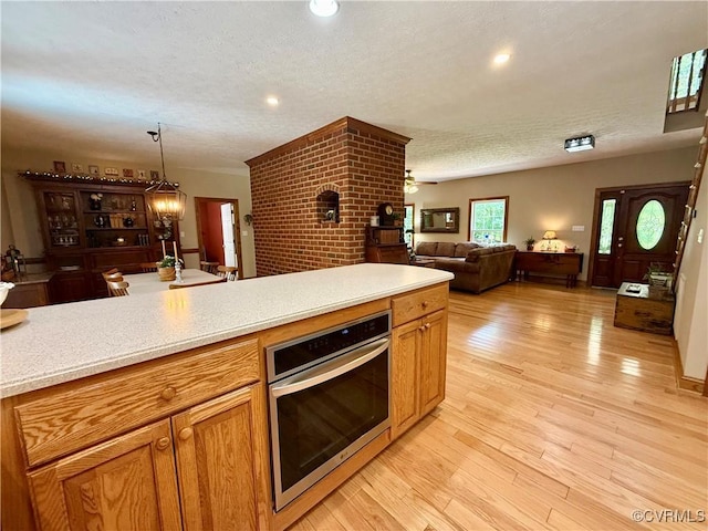 2222 Green Level Rd, King William, VA 23086 - kitchen featuring oven, a textured ceiling, light countertops, open floor plan, and light wood-type flooring