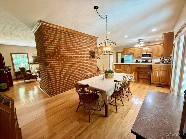 2222 Green Level Rd, King William, VA 23086 - dining area featuring brick wall, light wood finished floors, recessed lighting, a ceiling fan, and a chandelier