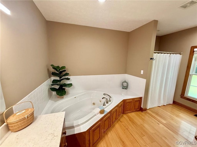 2222 Green Level Rd, King William, VA 23086 - bathroom featuring a jetted tub, wood finished floors, and a shower with curtain