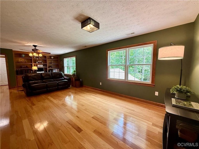 2222 Green Level Rd, King William, VA 23086 - living room with a ceiling fan, a textured ceiling, light wood finished floors, and built in shelves
