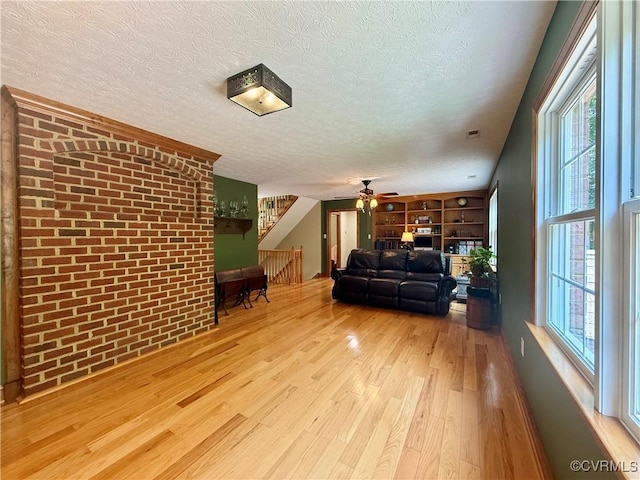 2222 Green Level Rd, King William, VA 23086 - living area featuring wood finished floors, a textured ceiling, a ceiling fan, healthy amount of natural light, and built in shelves