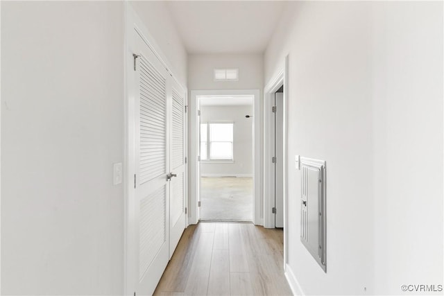 corridor featuring light wood-type flooring, visible vents, and baseboards