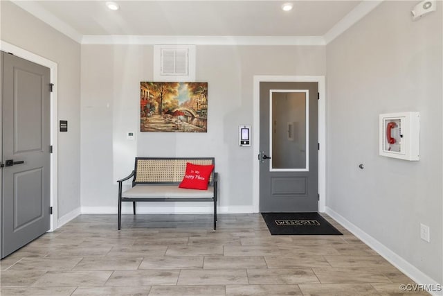 entrance foyer with wood tiled floor, visible vents, crown molding, and baseboards