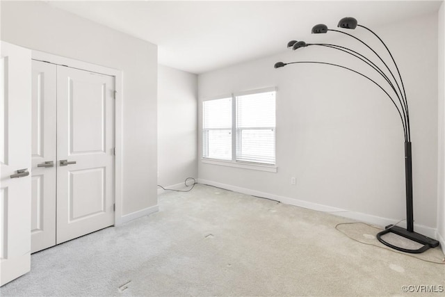 unfurnished bedroom with a closet, carpet flooring, and baseboards