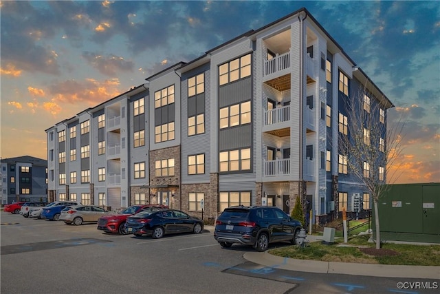 property at dusk with uncovered parking