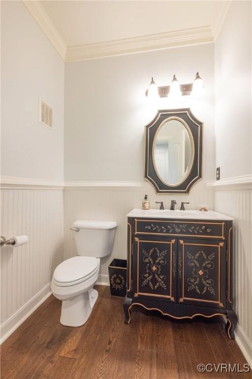 8907 First Branch Ln, Chesterfield, VA 23838 - half bathroom featuring a wainscoted wall, wood finished floors, toilet, vanity, and ornamental molding