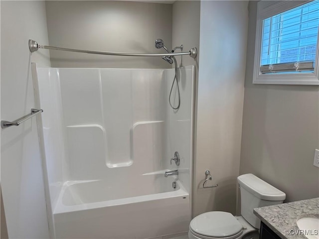 bathroom featuring toilet, vanity, and bathing tub / shower combination