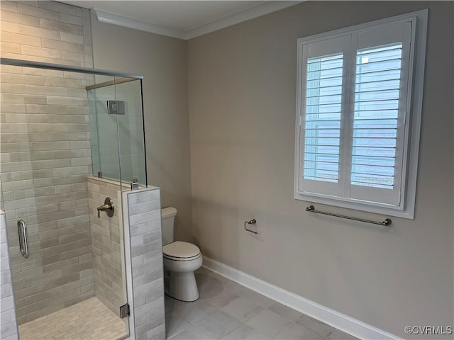 bathroom featuring baseboards, toilet, a healthy amount of sunlight, crown molding, and a stall shower