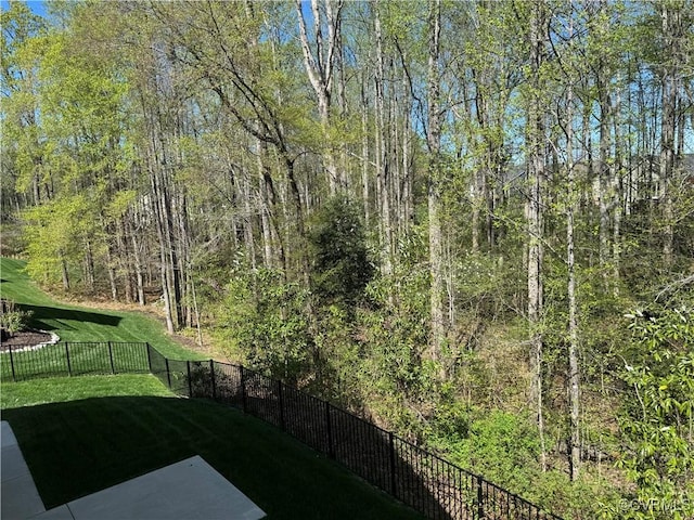 view of yard with a view of trees and fence