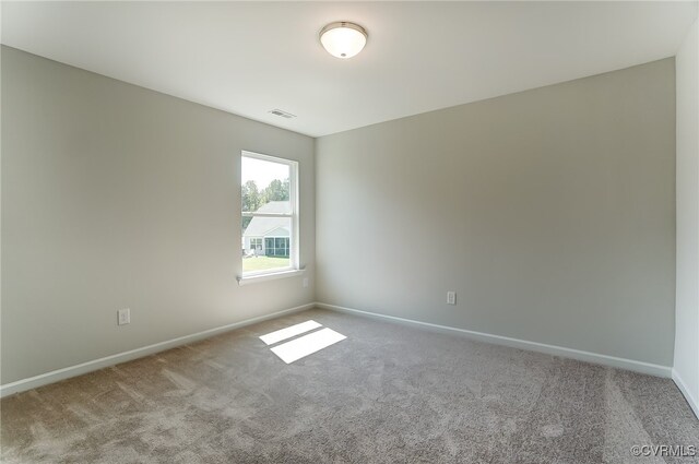 spare room featuring baseboards, carpet flooring, and visible vents