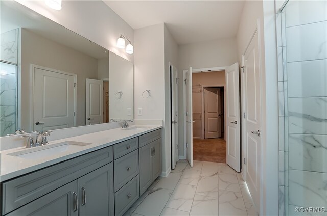bathroom with double vanity, baseboards, a sink, and marble finish floor