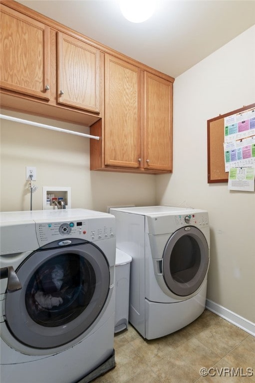 laundry area featuring washer and dryer, cabinet space, and baseboards