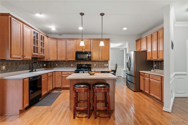 kitchen featuring black appliances, light countertops, and light wood-type flooring