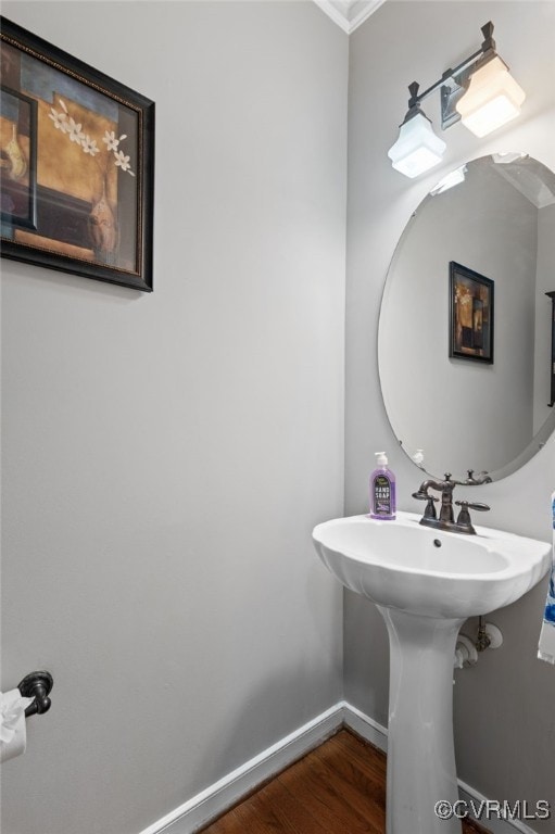 bathroom with wood finished floors, baseboards, and crown molding