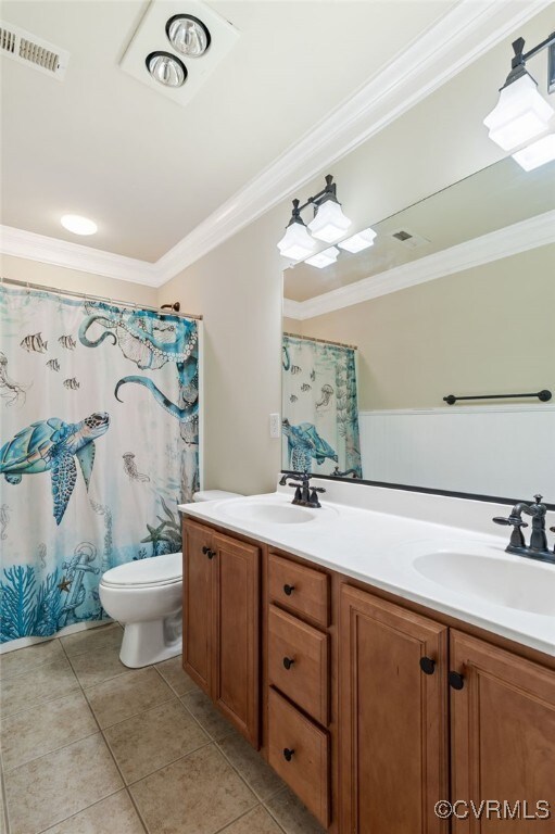full bathroom with crown molding, toilet, double vanity, tile patterned flooring, and a shower with curtain