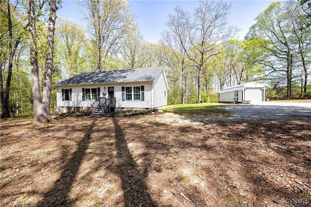 single story home featuring crawl space, driveway, an outbuilding, and a detached garage