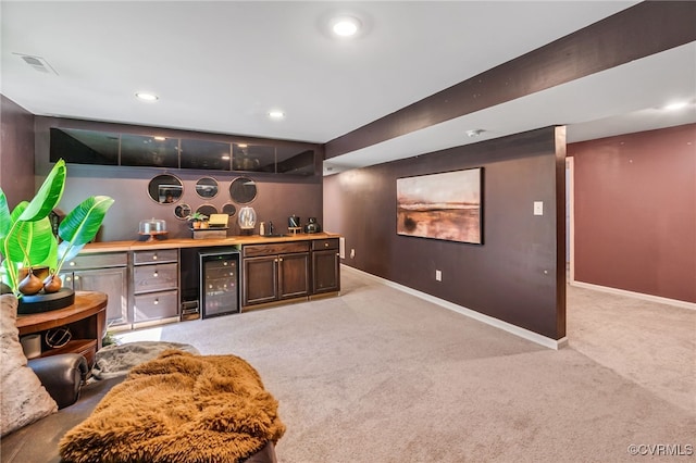bar with indoor bar, baseboards, light colored carpet, and wine cooler