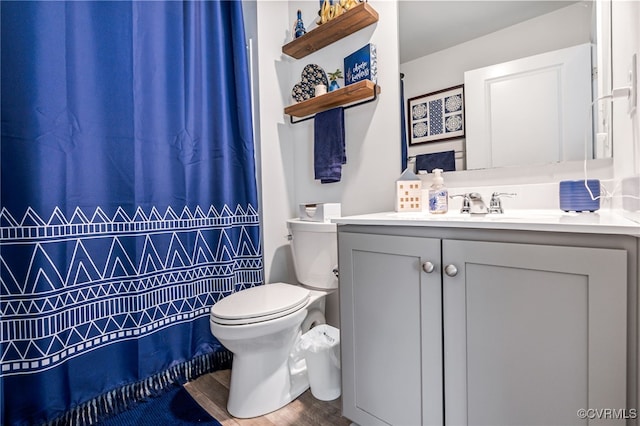 full bathroom featuring a shower with shower curtain, wood finished floors, toilet, and vanity