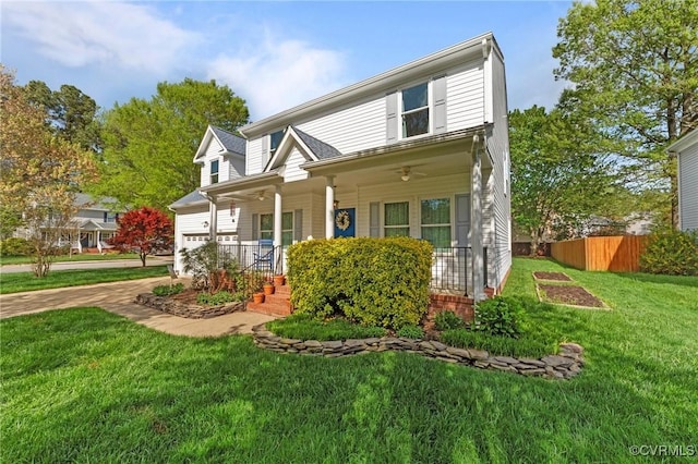 traditional-style house featuring a front lawn, fence, an attached garage, and covered porch