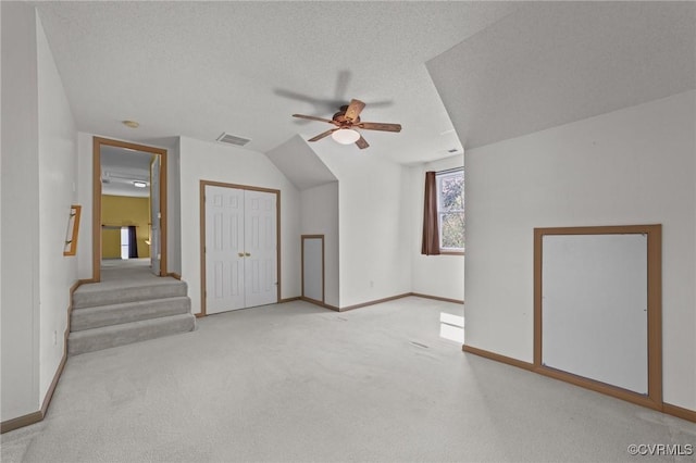 bonus room featuring visible vents, baseboards, ceiling fan, a textured ceiling, and carpet floors