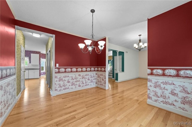dining area featuring baseboards, a chandelier, wood finished floors, and wallpapered walls