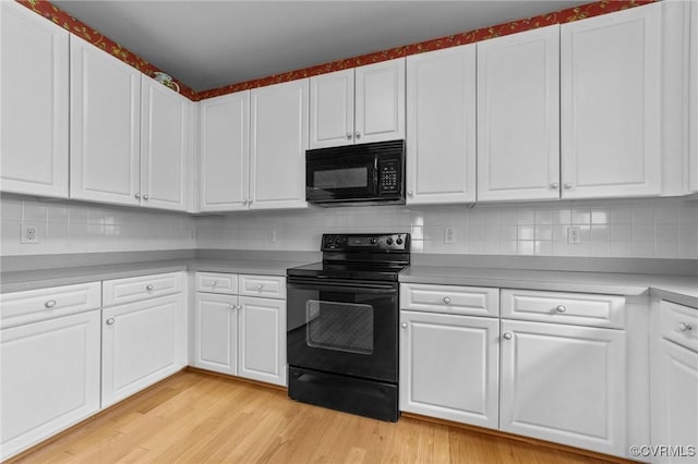 kitchen featuring light wood-style floors, light countertops, white cabinetry, and black appliances