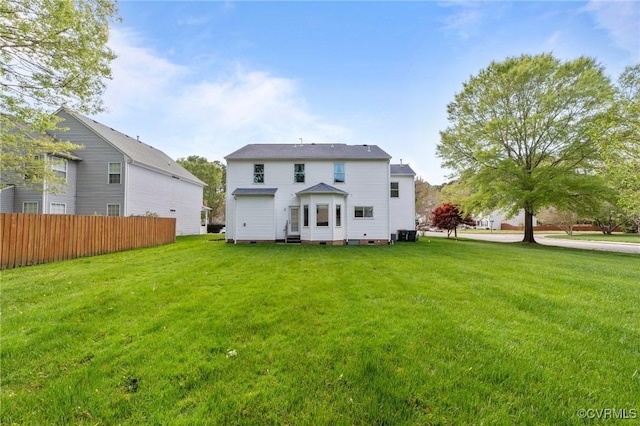 back of property with crawl space, fence, and a lawn