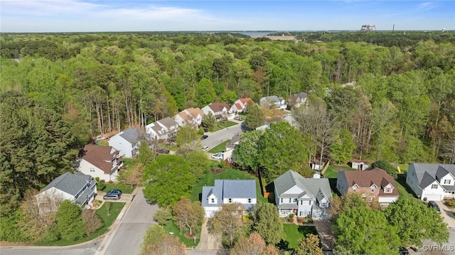 drone / aerial view featuring a wooded view and a residential view