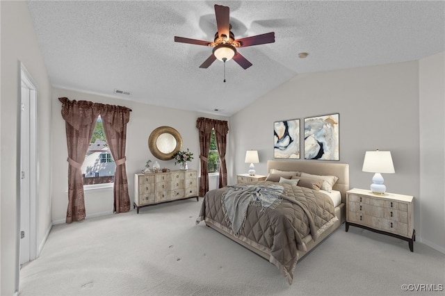 bedroom with visible vents, a ceiling fan, a textured ceiling, carpet floors, and lofted ceiling