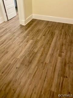 interior space featuring baseboards and wood finished floors