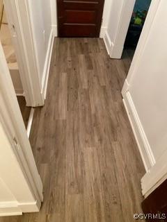 hall featuring baseboards and wood finished floors