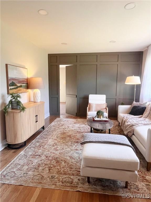 living area featuring recessed lighting, wood finished floors, and a decorative wall