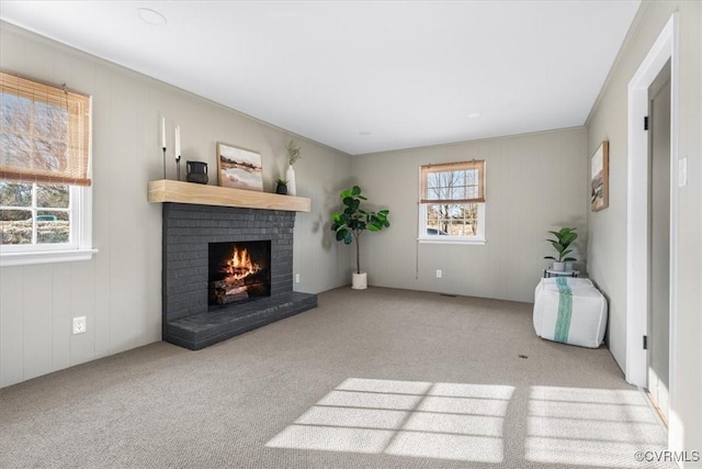carpeted living area with a brick fireplace and crown molding