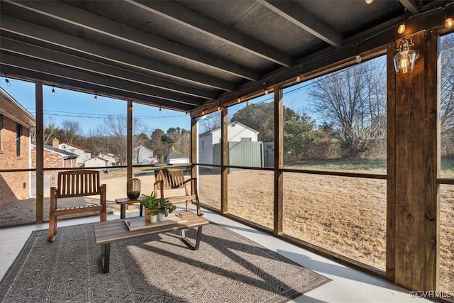 unfurnished sunroom featuring beamed ceiling