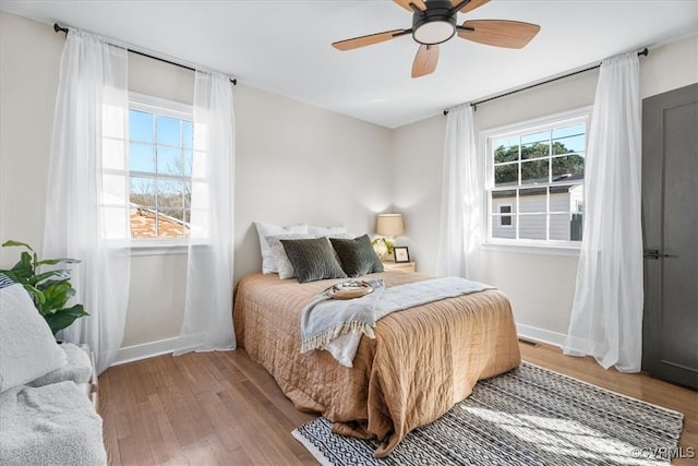 bedroom with baseboards, ceiling fan, and wood finished floors