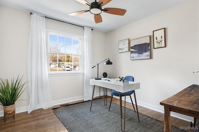 office space with baseboards, ceiling fan, and wood finished floors