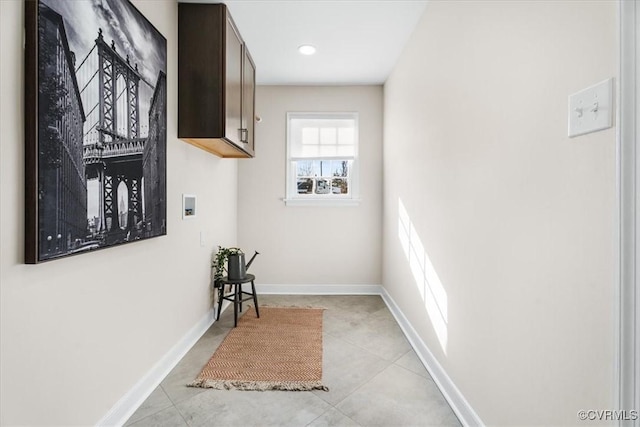 laundry area featuring baseboards, hookup for a washing machine, cabinet space, and light tile patterned flooring