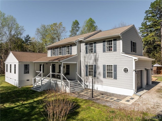 view of front of house with covered porch, a garage, and a front yard