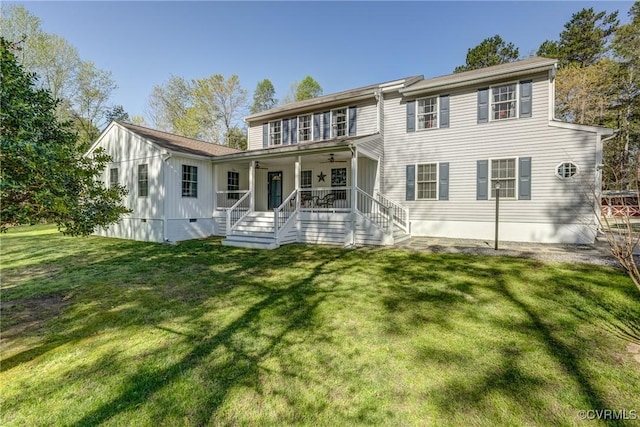 back of house with ceiling fan, covered porch, a lawn, and board and batten siding