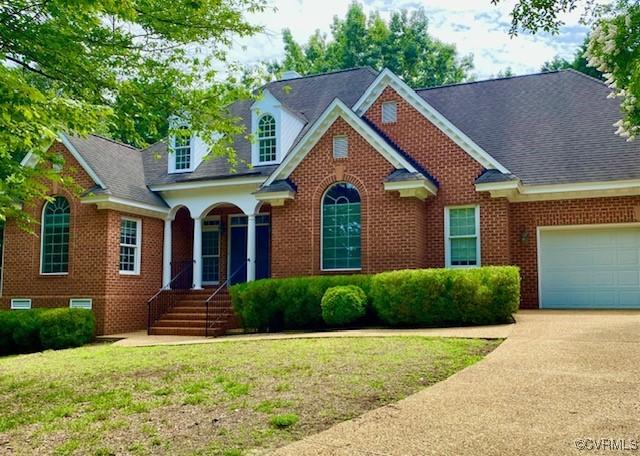 132 Warwick Hls, Williamsburg, VA 23188 - traditional home with an attached garage, concrete driveway, a front lawn, and brick siding